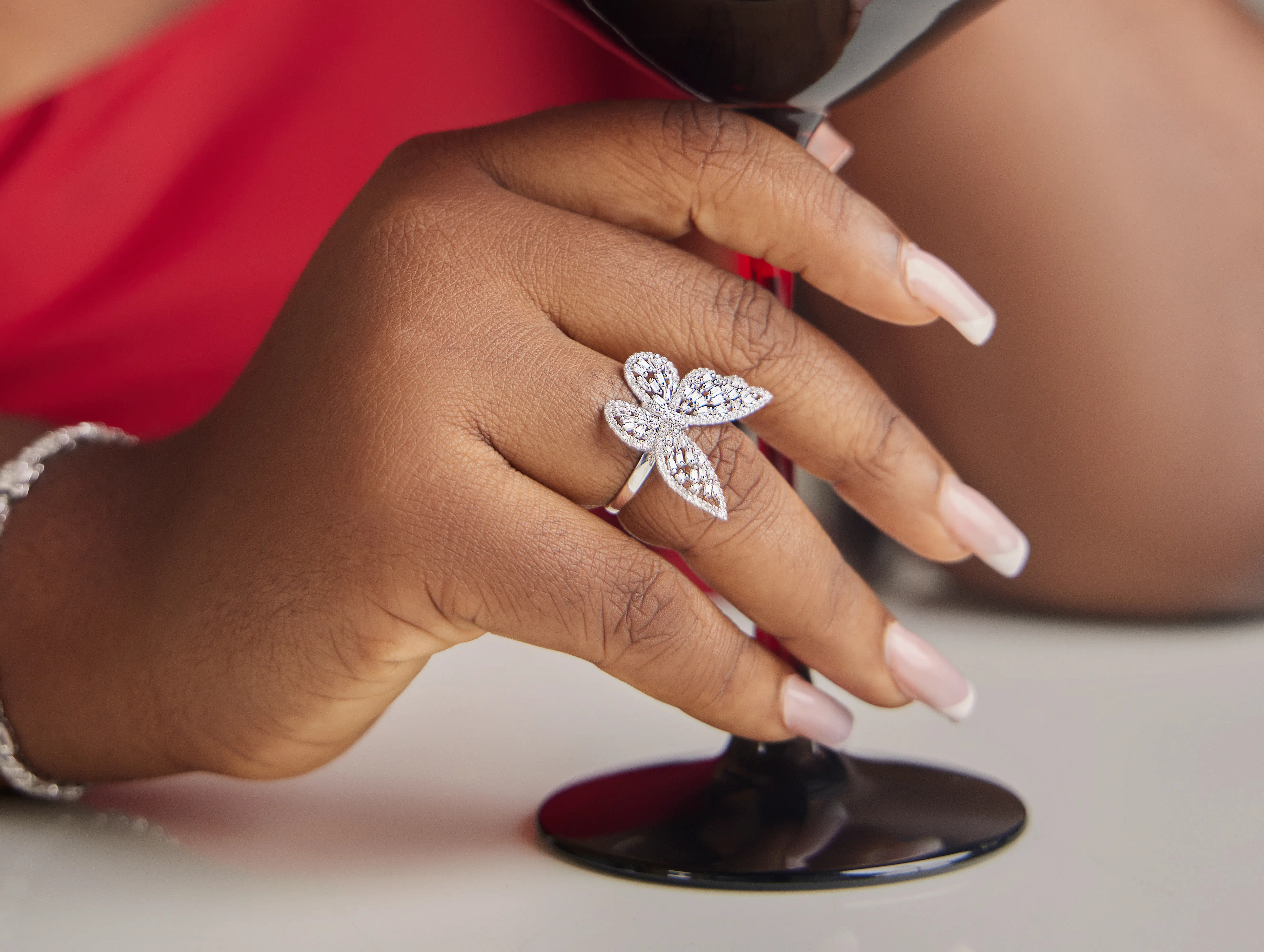 Hands with a butterfly shaped white gold diamond ring on one finger