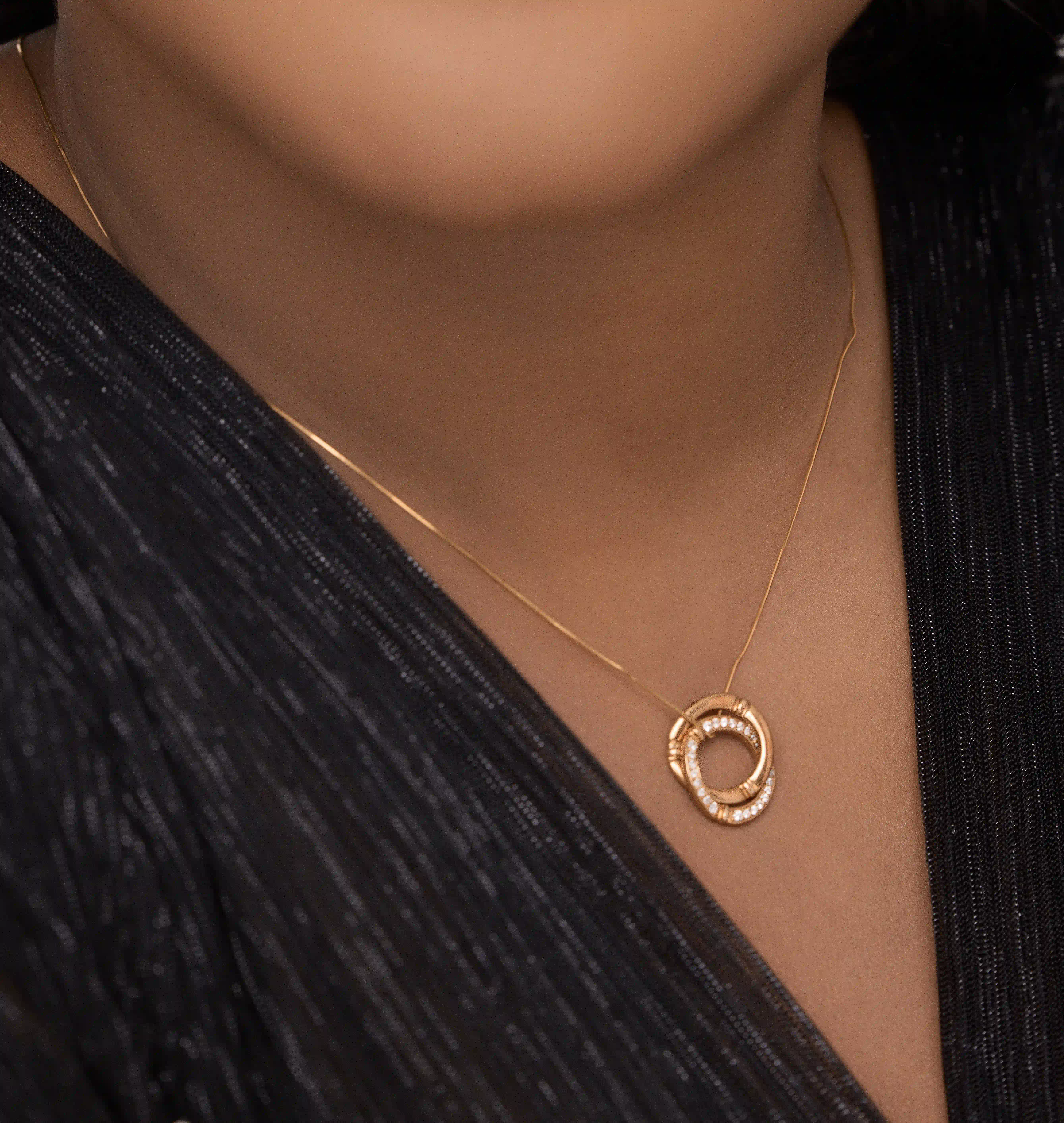 Side angle showing the dimensional design of the 18k gold bamboo pendant and chain clasp