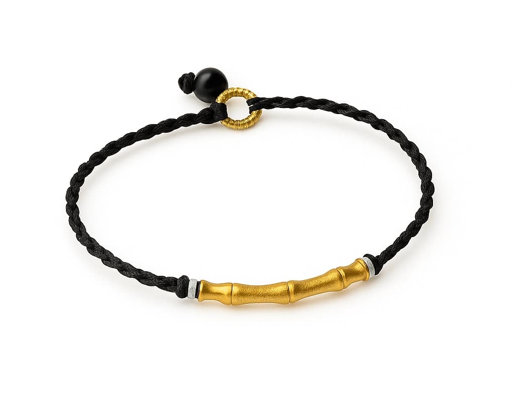 Close-up of black bamboo woven bracelet with 24K gold accents on a wrist